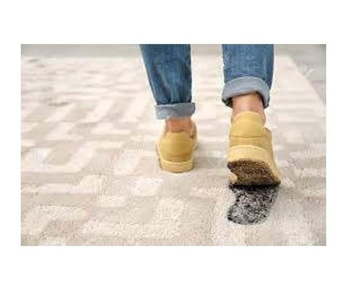 Person walking on clean carpet tracking soot with their shoes